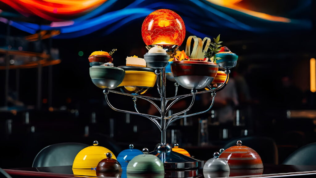 Futuristic gourmet dish arranged on an immersive galaxy-themed tray resembling a solar system at WOOHOO Dubai.