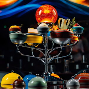 Futuristic gourmet dish arranged on an immersive galaxy-themed tray resembling a solar system at WOOHOO Dubai.