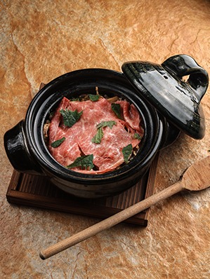 Premium Wagyu Donabe served in a traditional Japanese clay pot with thinly sliced Wagyu beef and fresh herbs at a fine dining restaurant in Dubai