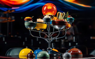 Futuristic gourmet dish arranged on an immersive galaxy-themed tray resembling a solar system at WOOHOO Dubai.